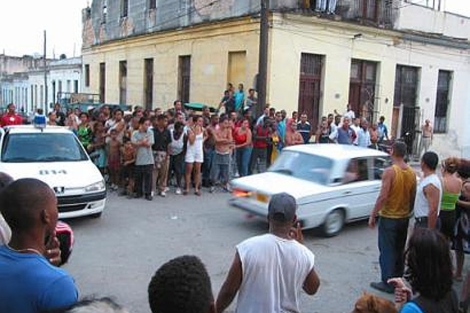 Vecinos observan cómo se llevan detenido a Raúl Rivero en la Primavera Negra de 2003.