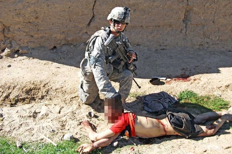 Un soldado posa para la cámara agarrando un cadáver por el cabello. | Der Spiegel