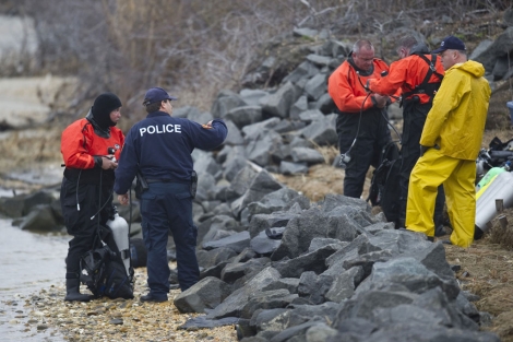 Miembros de la Policía buscan restos humanos en una playa de Long Island. I AFP