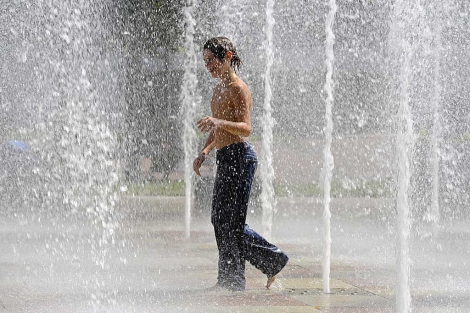 Un niño se refresca en una fuente por el intenso calor en Kansas City. | Efe