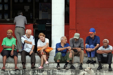 Un grupo de ancianos conversa frente a una bodega en La Habana. | Efe