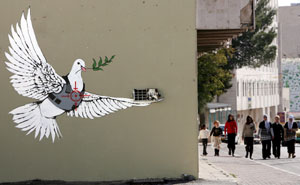 Una paloma de la paz con chaleco antibalas y un visor de un francotirador dibujado sobre su pecho en la ciudad de Belén, Cisjordania. (Foto: EFE)