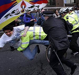Polic�as brit�nicos se enfrentan a un manifestante que intent� atacar la llama ol�mpica en Londres. (Foto: AP)