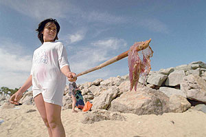 Una niña muestra una medusa en la playa de Nova Icaria, en Barcelona. (Foto: Jorge Moreno)