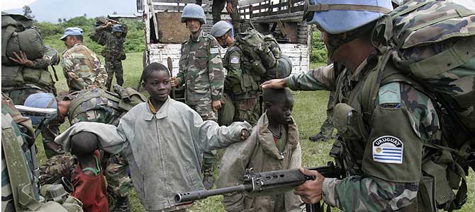 Soldados uruguayos de la ONU, con unos niños en Kibati, a 12 km de Goma. (Foto: AP). Más imágenes