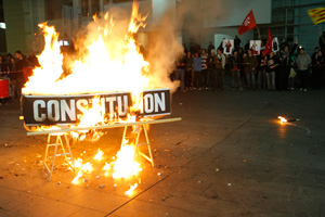 Un encapuchado ha quemado un ataúd en el que se podía leer la palabra 'Constitución'. (Foto: Santi Cogolludo)