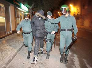 La Guardia Civil detiene a uno de los participantes en los distrubios. (Foto: EFE)