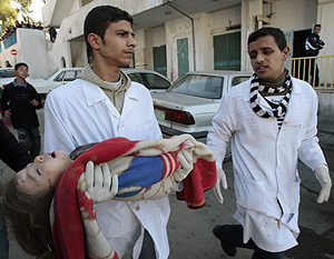 Dos médicos transportan el cadaver de una niña muerta durante los ataques. (Foto: Reuters)