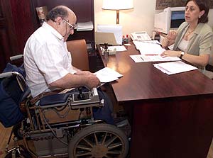 Un hombre en silla de ruedas presenta un escrito en un despacho. (Foto: Ángel Casaña)