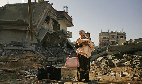 Una palestina, con su hijo ante las ruinas en Gaza. | AP