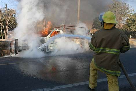 Un bombero apaga el fuego de la camioneta atacada. | EFE
