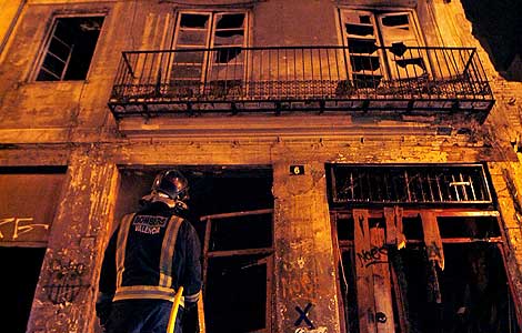 Un bombero observa la fachada del edificio donde se originó el incendio. (Foto: EFE)