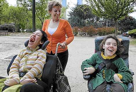 Ana García pasea por Madrid con sus dos hijas, María (dcha.) de 20 años y Clara, de 25, con de parálisis cerebral