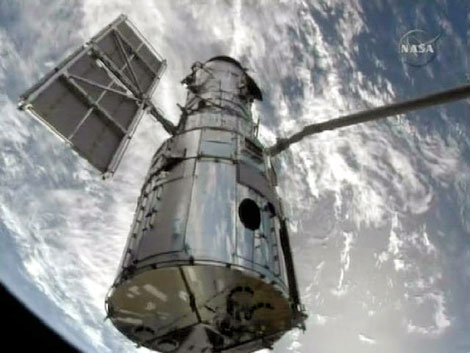 El telescopio 'Hubble' enganchado al brazo robótico del 'Atlantis'. / NASA TV