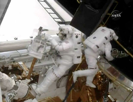 Los astronautas, durante la reparación de los giroscopios en plena caminata espacial. | Reuters