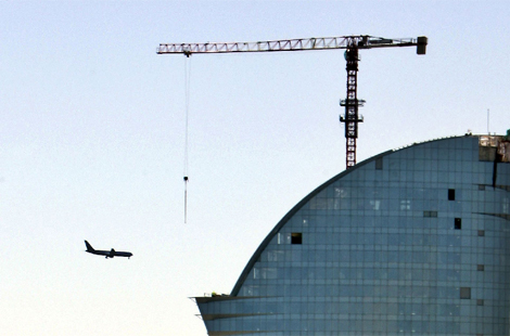Un avión pasa junto al nuevo hotel Vela de Barcelona. | Efe