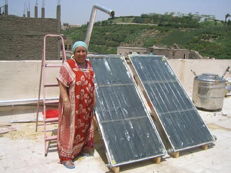 Una mujer egipcia enseña su calentador solar en la azotea de su casa. /Thomas Culhane