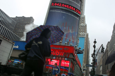 Una mujer camina frente al nuevo contador de emisiones en Nueva York. | AFP