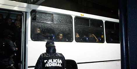 Un agente custodia el autobús donde van parte de los detenidos. | Efe Un agente custodia el autobús donde van parte de los detenidos. | Efe
