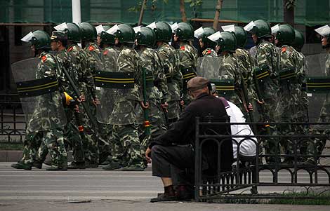 Unos ciudadanos contemplan a los soldados del Ejército chino. | Reuters Unos ciudadanos contemplan a los soldados del Ejército chino. | Reuters