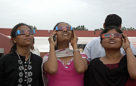 Visitantes a la Ciudad de la Ciencia en Ahmadabad prueban unas gafas para ver el eclipse. | Ap