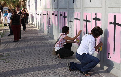 Varias mujeres pintan cruces de protesta en Juárez. | Efe