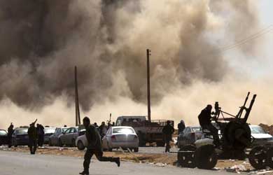 Rebeldes libios se cubren en los bombardeos en Ras Lanuf. | Afp