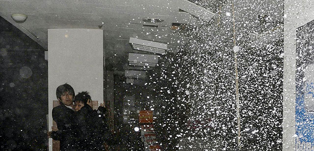 Dos personas se protegen en una librería en pleno seísmo. | Reuters VEA MÁS FOTOS