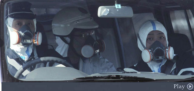 Oficiales de policía patrullan con máscaras de gas en el área de la planta nuclear. | AP