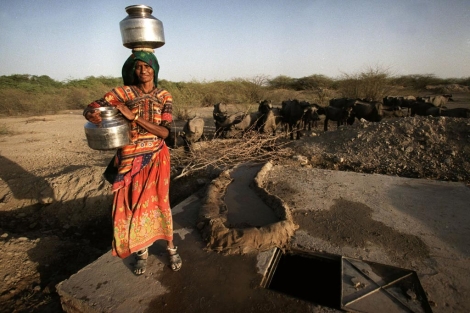 Una mujer recoge agua de un pozo provisional en India.| Ap Una mujer recoge agua de un pozo provisional en India.| Ap
