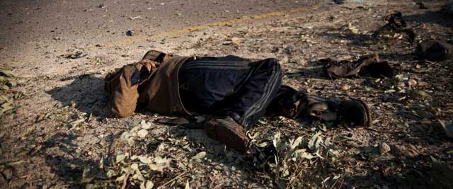 El cadáver de un rebelde, en la carretera de entrada a Ajdabiya. | Efe