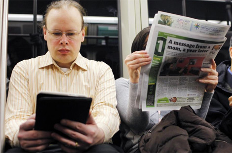 Un lector de libro electrónico junto a otro de papel. | Reuters