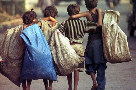 Varios niños indios caminan por una calle de Calcuta tras un día de trabajo.