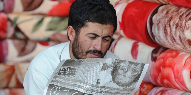 Un ciudadano paquistaní lee la noticia de la muerte de Bin Laden en un periódico. | Afp