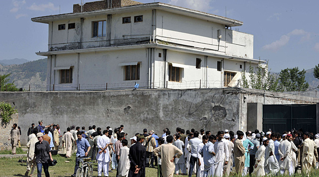 Vecinos y periodistas junto al complejo en el que se ocultaba el terrorista. | AFP