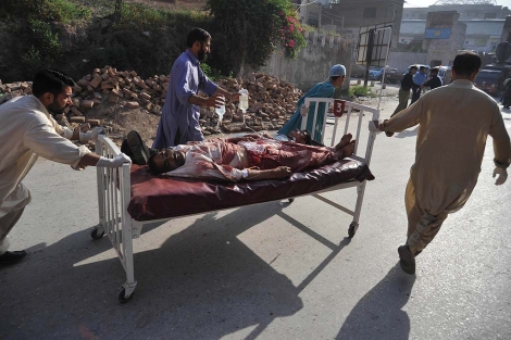 Sanitarios y personas voluntarias trasladan a un herido por el atentado. | Afp MAS IMAGENES