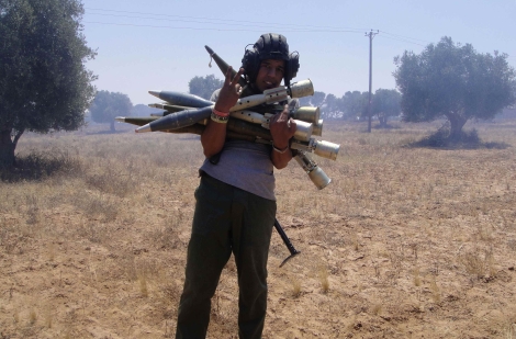 Un rebelde posa con cohetes incautados a las fuerzas de Gadafi. | Reuters