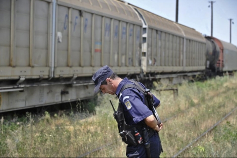 Un policía rumano frente al tren que transportaba armamento en Rumanía. | AP