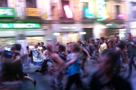 Un grupo de indignados corre por la calle Preciados de Madrid. | EL MUNDO