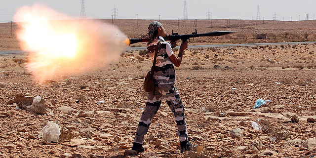 Un rebelde libio dispara un lanzacohetes contra las fuerzas leales a Gadafi en Bani Walid, al sur de Trípoli. | Efe