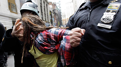 Dos agentes arrestan a un manifestante. | AP