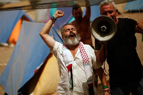 Sánchez Gordillo, junto a un jornalero en la finza. | Reuters