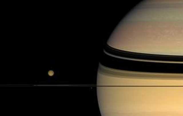 La luna Titán, orbitando el planeta Saturno. | NASA