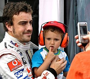 Alonso, fotografiado con un niño en brazos en Montmeló. (Foto: AP)