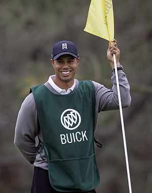 Woods atiende la bandera en uno de los nueve hoyos que jug� Abel. (Foto: AP)