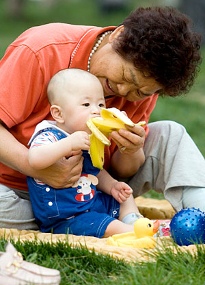 Una mujer da de comer un plátano a su hijo en un parque de Pekín. (Foto: EFE) Una mujer da de comer un plátano a su hijo en un parque de Pekín. (Foto: EFE)