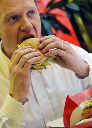 El director de McDonalds en Hungría come una hamburguesa de su restaurante. (Foto: Attila Kisbenedek | AFP)