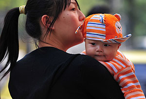 Una mujer lleva a su hijo a un hospital de Pek�n. (Foto: Frederic J. Brown | AFP)