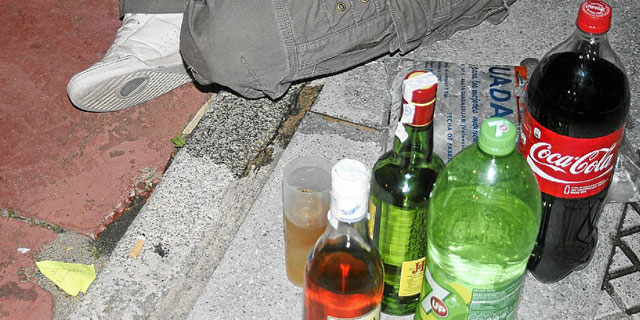 Botellas de alcohol y de refrescos en la acera durante un botellón.| E. Domínguez
