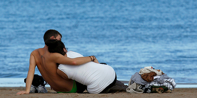 Una pareja se abraza en la playa de la Malvarrosa, Valencia. | Efe | Kai Försterling